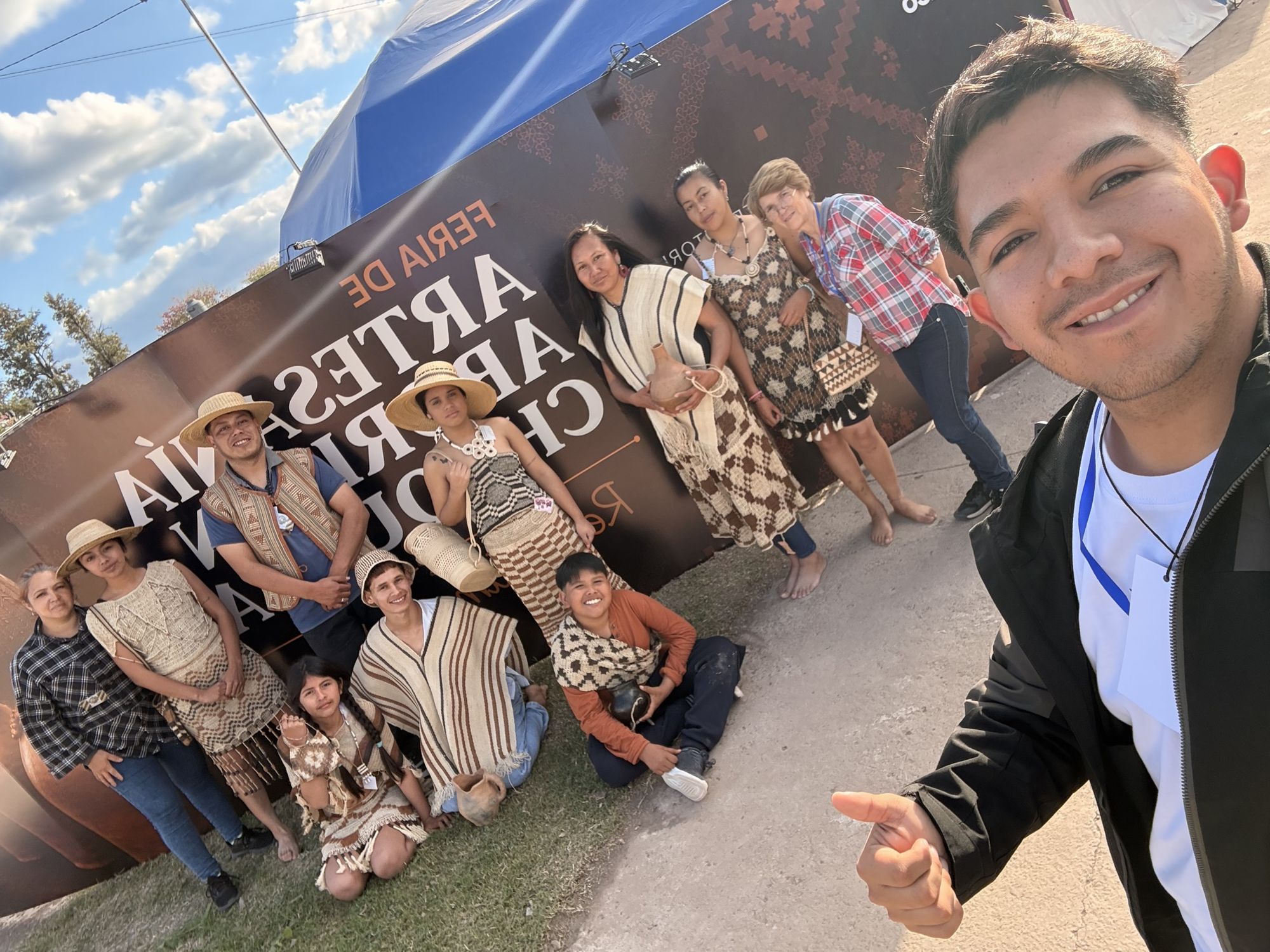 Orlando Pérez junto a artesanas y artesanos con sus vestimentas tradicionales en la 49ª Feria